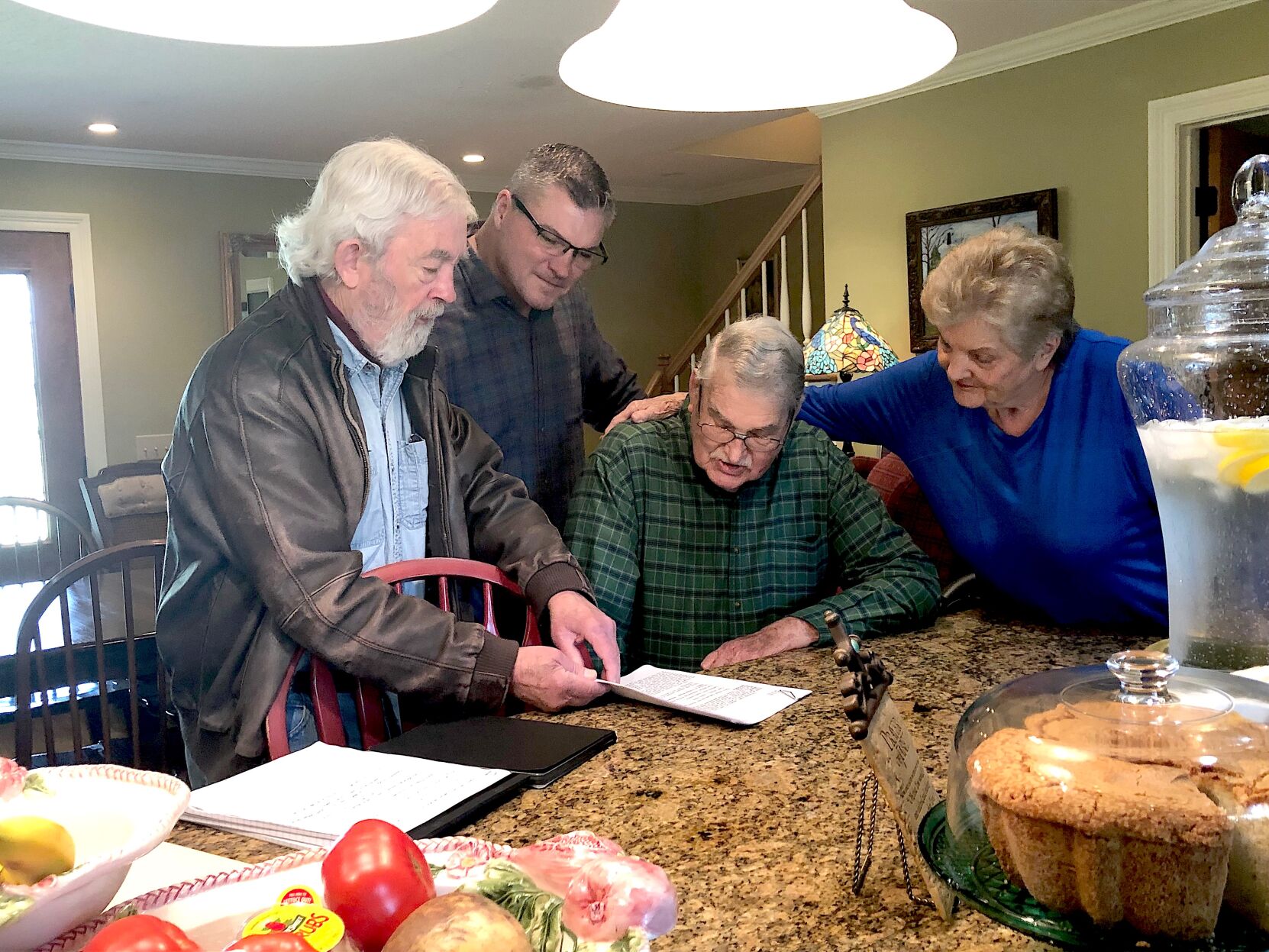 6.12 Landrum, Author Curtis Wilkie, left, with Tom Landrum seated beside him, wife Anne Landrum and Mike Landrum looking over FBI records. (Photo submitted).jpeg